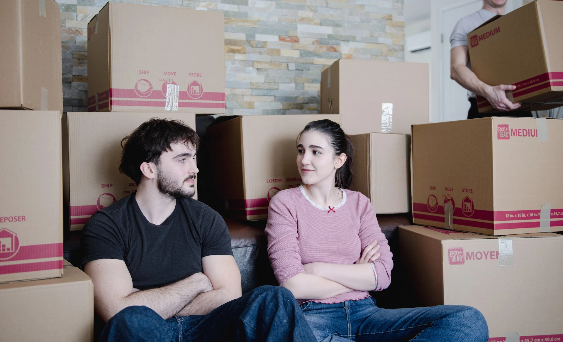 Family relaxing among packed moving boxes during a residential move